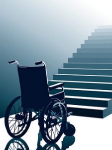 Cette image montre un fauteuil roulant vide en face d'escaliers